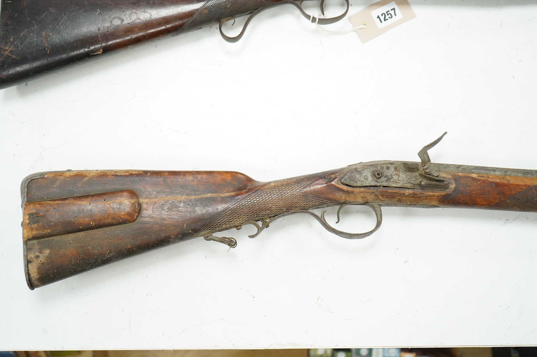 A 32 bore Continental flintlock rifle, unsigned lock, (cock missing) iron mounts and fully stocked, chequered small, sliding patch box cover, (ramrod missing)